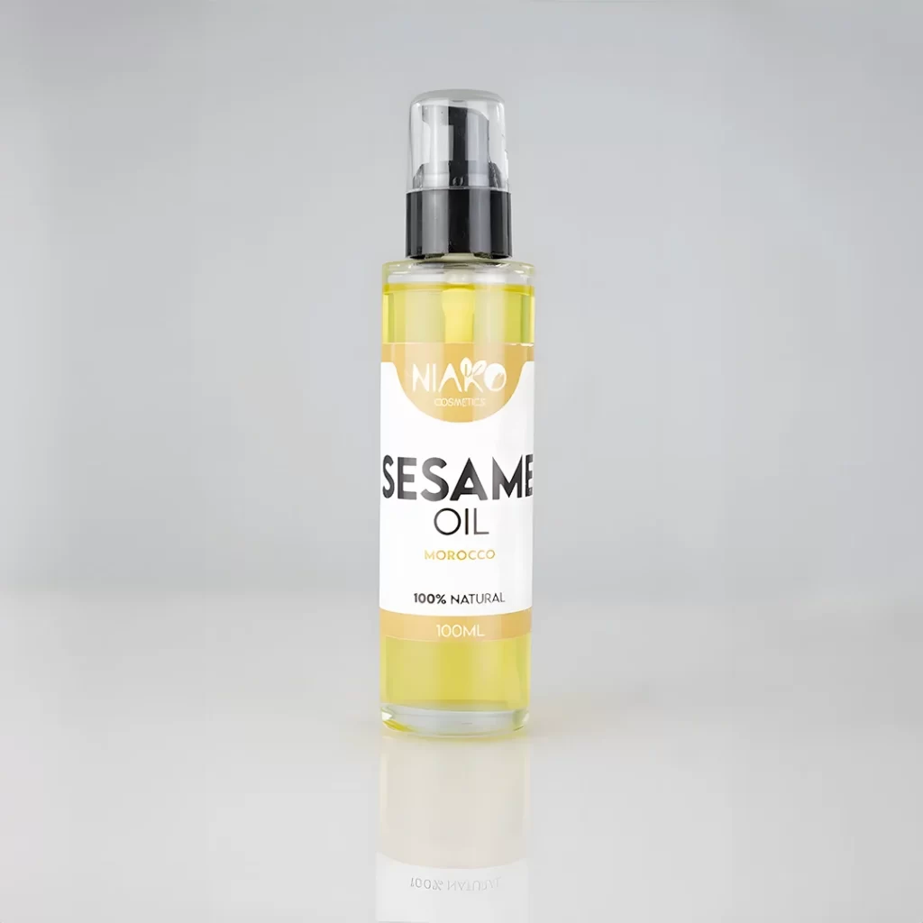 Bouteille d'huile de sésame 100% naturelle de 100ml de NIARO Cosmetics avec étiquettes indiquant origine marocaine et bienfaits régénérants, réparateurs, hydratants et nourrissants.